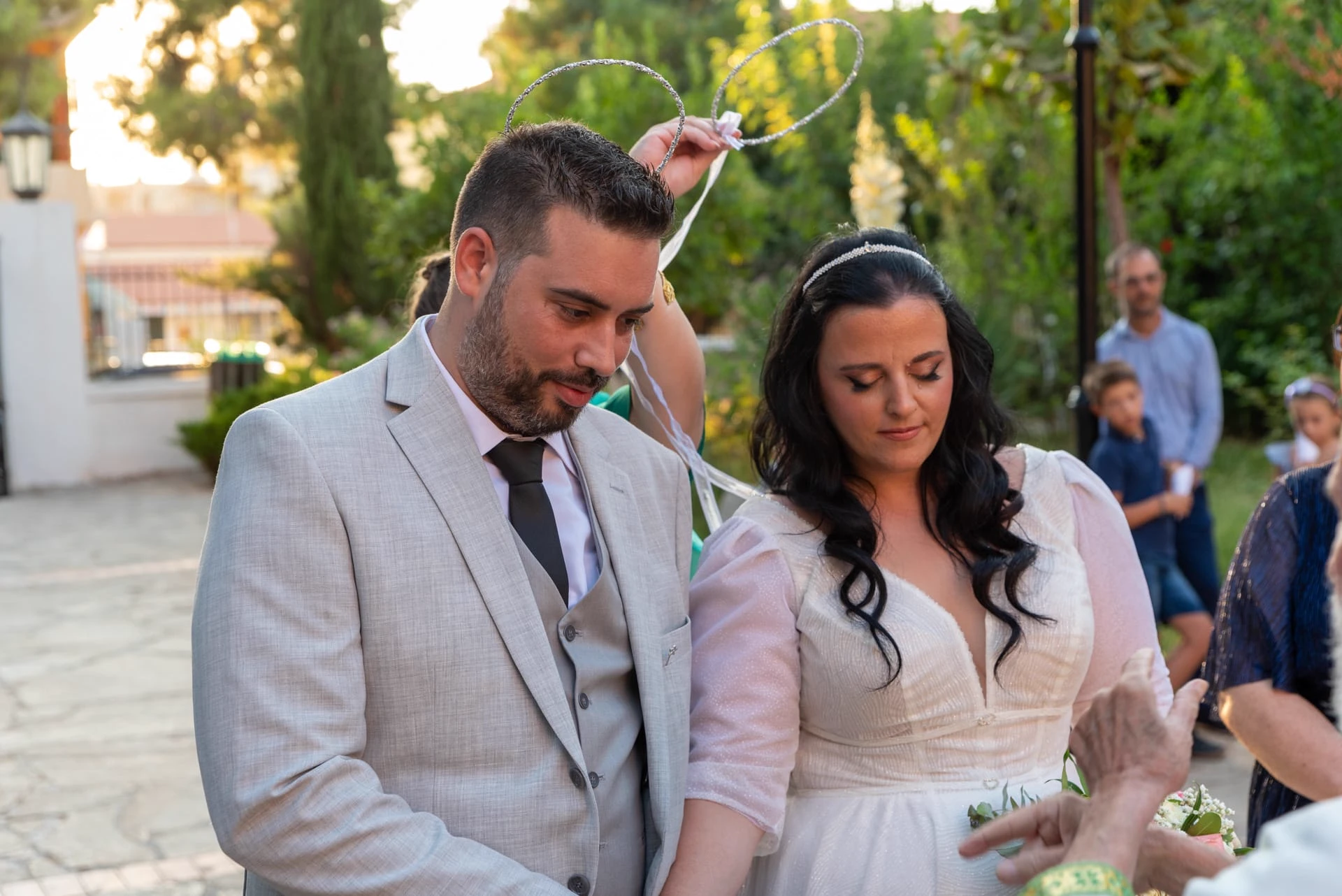 Bride and groom walking through the gardens of Agia Magdalini Church after their wedding ceremony in Chania, Crete.